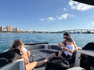 A family enjoys a relaxing moment on a boat, with a stunning cityscape in the background. Perfect for capturing cherished memories on the water.