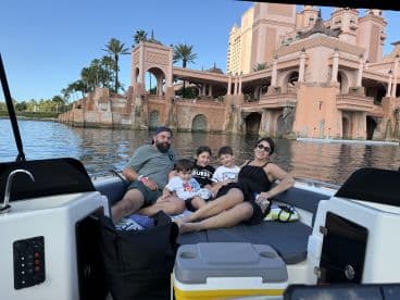 A family enjoys a relaxing moment on a boat, with a stunning waterfront view in the background — perfect for memorable outings and quality time together.