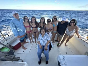 A joyful group of family and friends poses together on a boat, enjoying a fun day on the water — perfect for creating lasting memories.
