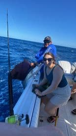 A thrilling moment as a group celebrates their fishing catch aboard a boat, showcasing the excitement of deep-sea fishing adventures.