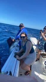 A group celebrates a successful fishing trip, showcasing a marlin caught on the boat — an exhilarating experience on the water.