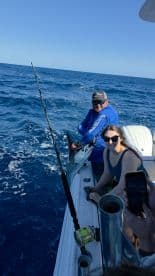 A joyful moment captured while fishing at sea, showcasing a successful catch and the excitement of the anglers aboard.