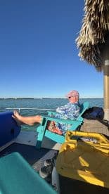 A relaxed individual enjoys the serene waters from a comfortable chair on the boat, perfect for unwinding during a day on the water.