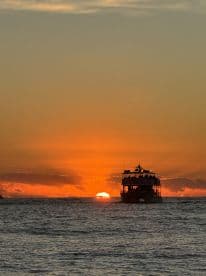 A stunning sunset view with a boat silhouetted against the vibrant sky, perfect for capturing the essence of evening cruises.
