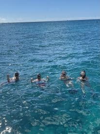A group of friends enjoys snorkeling in the crystal-clear waters, showcasing the perfect adventure for ocean lovers.
