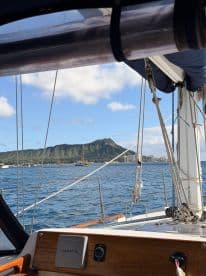 A scenic view from the helm of a sailboat, showcasing the iconic Diamond Head in the background — perfect for capturing the essence of a sailing adventure in Hawaii.