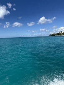A stunning view of a sailboat on the horizon against a backdrop of vibrant blue waters and a clear sky, perfect for showcasing the beauty of ocean adventures.