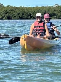 Two friends enjoy a kayaking adventure through serene waters, showcasing the fun and excitement of outdoor water activities.
