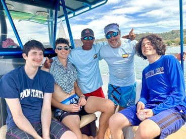 A cheerful group of friends poses on a boat, enjoying their time together on the water — perfect for memorable adventures and celebrations.