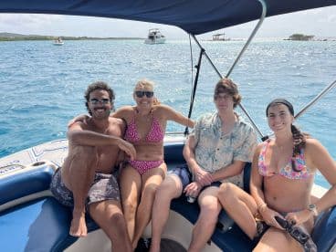 A lively group enjoys a sunny day on a boat, showcasing the perfect atmosphere for fun and relaxation on the water.