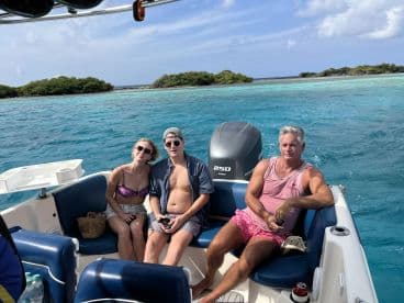 A group of friends relaxes on a boat in vibrant turquoise waters, enjoying a day out on the ocean — perfect for creating unforgettable memories.