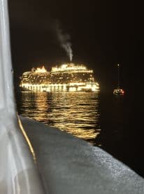 A stunning view of a brightly lit cruise ship at night, showcasing its grandeur against the dark waters, perfect for capturing the essence of nighttime boating adventures.