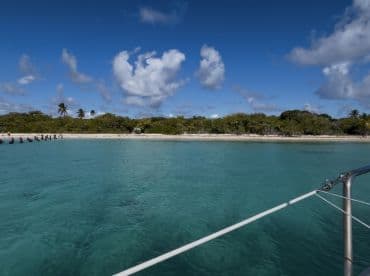 A stunning view of a tranquil coastline with clear turquoise waters and lush greenery, perfect for island hopping adventures.