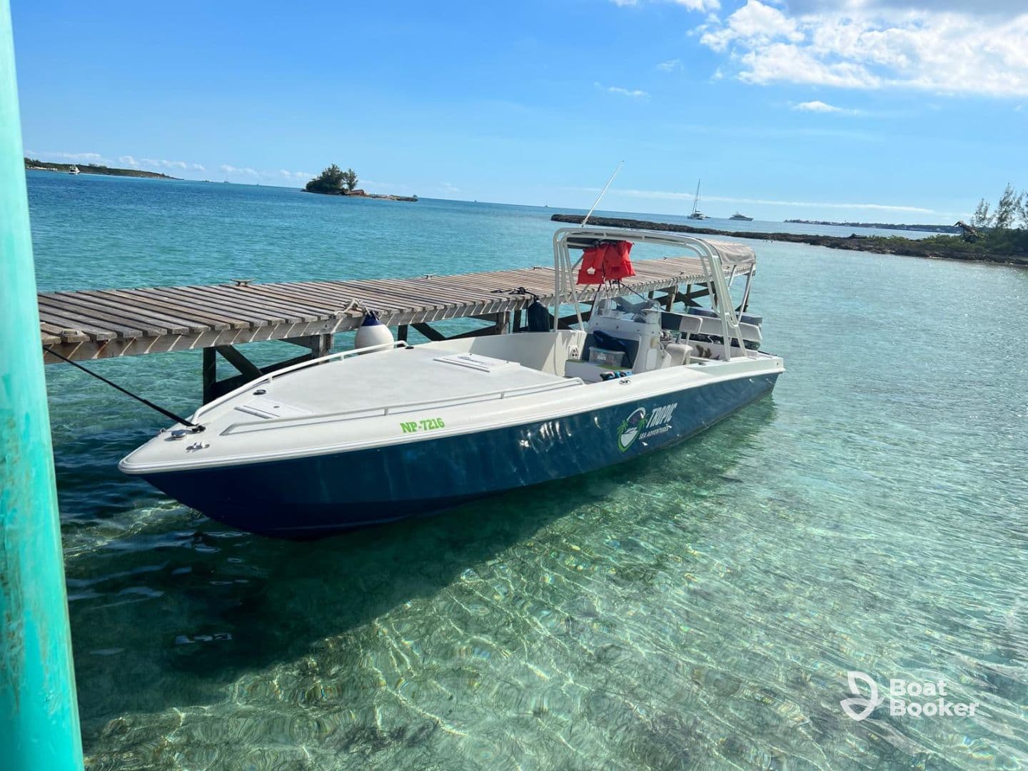 A sleek speedboat docked at a wooden pier, surrounded by clear turquoise waters, perfect for a day of adventure on the sea.