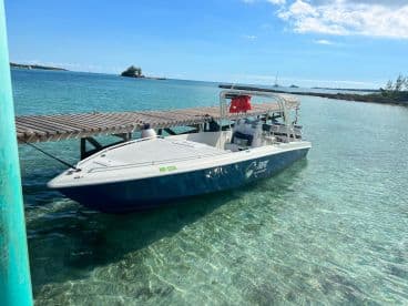 A sleek speedboat docked at a wooden pier, surrounded by clear turquoise waters, perfect for a day of adventure on the sea.