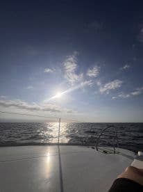 A serene view from the deck of a boat, showcasing the sun reflecting on the water, perfect for capturing the tranquility of a day at sea.