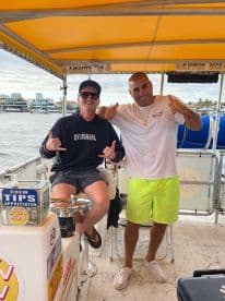 Two friends share a fun moment aboard a boat, showcasing camaraderie and good vibes on the water.
