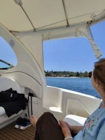 A serene moment inside a boat's cabin, showcasing comfortable seating and a view of the water, perfect for relaxing during a day on the water.