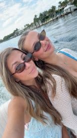 Two friends enjoy a sunny day on the water, capturing a fun selfie while boating — perfect for memorable outings and adventures.