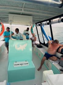 Inside view of a boat's helm area with guests interacting and relaxing, showcasing the comfortable seating and vibrant decor — perfect for a day on the water.