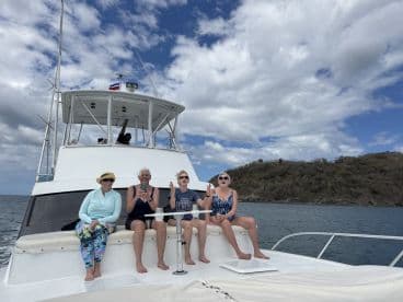 A cheerful group enjoys their time aboard a boat, capturing memories against a scenic ocean backdrop — perfect for fun outings and celebrations on the water.