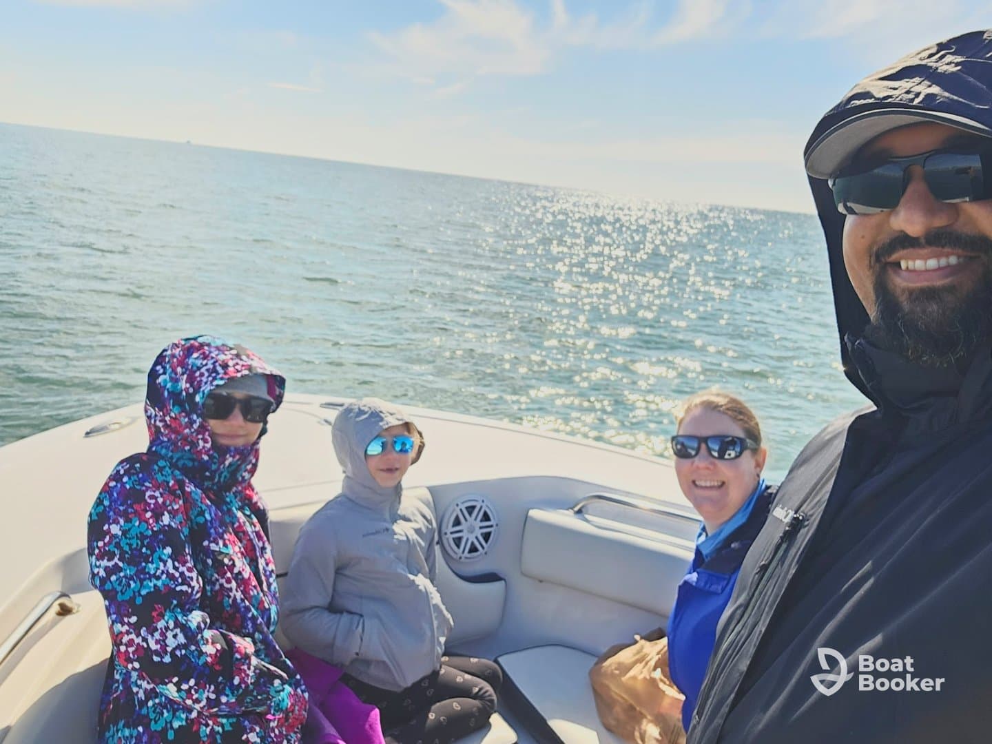 A joyful family enjoys a day out on the water, capturing smiles and memories aboard their boat. Perfect for family outings and adventures on the ocean.