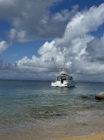 A fishing boat named 'Matt's C' anchored in calm waters under a dramatic sky, showcasing a serene boating experience.
