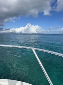 A serene view from the bow of a boat, showcasing calm waters and a dramatic sky — perfect for capturing the tranquility of a day on the water.