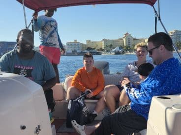 A lively group enjoys their time on a boat, with smiles and laughter, showcasing the joy of family outings on the water.
