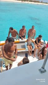 A lively group enjoys a fun day on the water, relaxing on a boat with drinks and laughter, perfect for summer outings and family adventures.