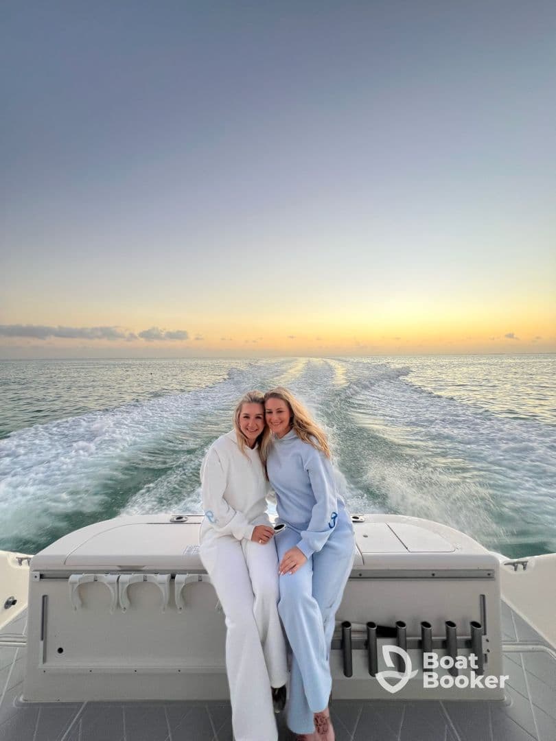 Two friends enjoy a beautiful sunset on a boat, capturing a perfect moment of friendship and celebration on the water.