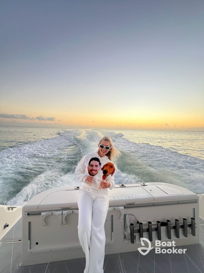 A joyful moment on a boat at sunset, featuring a woman holding playful cutouts of a dog and a person, perfect for capturing fun memories on the water.