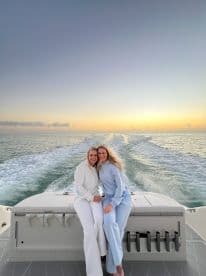 Two friends enjoy a beautiful sunset on a boat, capturing a perfect moment of friendship and celebration on the water.