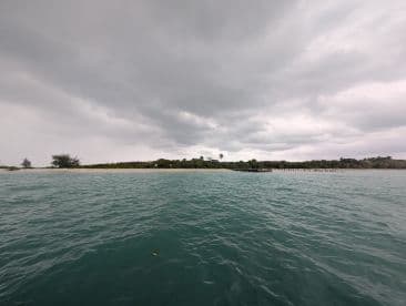 A cloudy scene over water with an island in the background, but the image lacks clarity and detail.