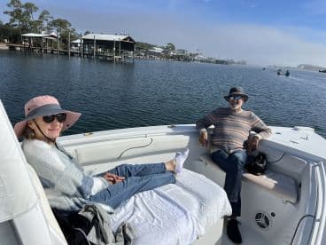 A couple enjoys a relaxing day on the water aboard a boat, surrounded by serene scenery — perfect for unwinding and enjoying nature.