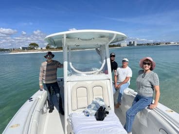 A cheerful group of friends enjoys a sunny day on a boat, showcasing the perfect setting for a coastal adventure.