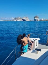 A couple shares a romantic moment on the deck of a boat, with stunning views of cruise ships in the background — perfect for memorable ocean adventures.