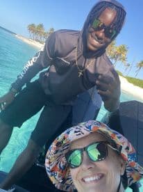 A joyful selfie featuring two individuals on a boat in a tropical setting, capturing the essence of fun and adventure on the water.
