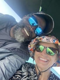 A joyful couple smiles for a selfie while enjoying their time on a boat, capturing the essence of fun and adventure on the water.