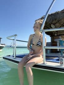 A young girl relaxes on the edge of a boat, enjoying the sun and water — a perfect summer day on the water.