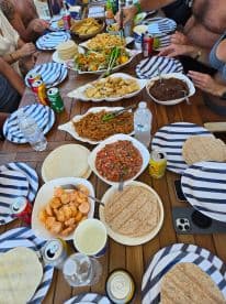 A vibrant spread of delicious food and drinks laid out on a dining table aboard a boat, perfect for enjoying a meal with friends while cruising on the water.
