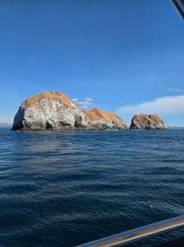 A stunning view of rocky islands rising from the ocean, showcasing the natural beauty of the coastline — perfect for scenic boat tours.