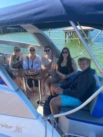 A joyful group celebrates on a boat with a delicious cake, perfect for memorable gatherings and special occasions on the water.