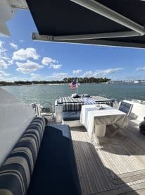 A cozy interior view of a yacht's dining area, featuring comfortable seating and a table set for relaxation, perfect for enjoying meals while cruising.