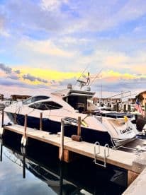 A stunning yacht docked at sunset, reflecting the vibrant colors of the sky in the calm waters — an ideal setting for luxury boating experiences.