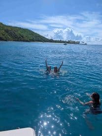 A joyful group enjoys a refreshing swim in crystal-clear waters, capturing the essence of fun and relaxation on a sunny day.