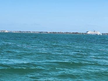 A distant view of a shoreline with boats and buildings, but the image lacks clarity and detail.