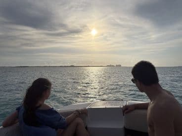 A couple enjoys a serene sunset view from their boat, creating a romantic atmosphere perfect for memorable moments on the water.