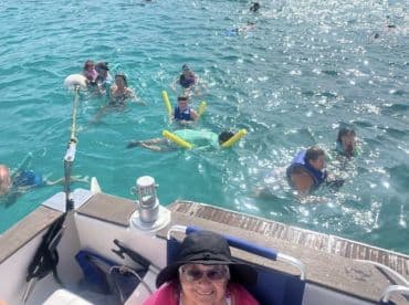 A lively group enjoys swimming in crystal-clear waters, showcasing family fun and snorkeling activities — perfect for memorable aquatic adventures.