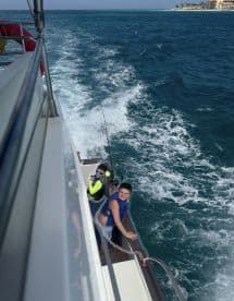 Two children enjoy a fishing experience on a boat, surrounded by the beautiful ocean — a perfect family adventure on the water.